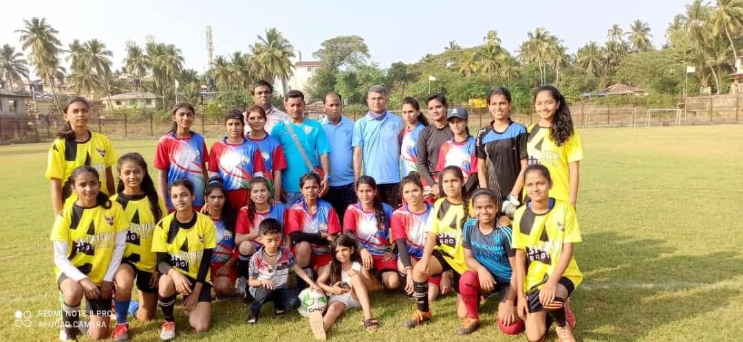 Girls and boys squads posing together on a grass field