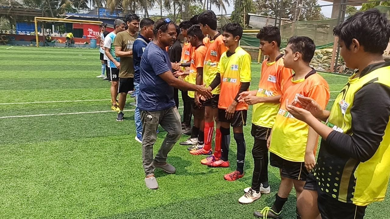 A coach hands medals to young players