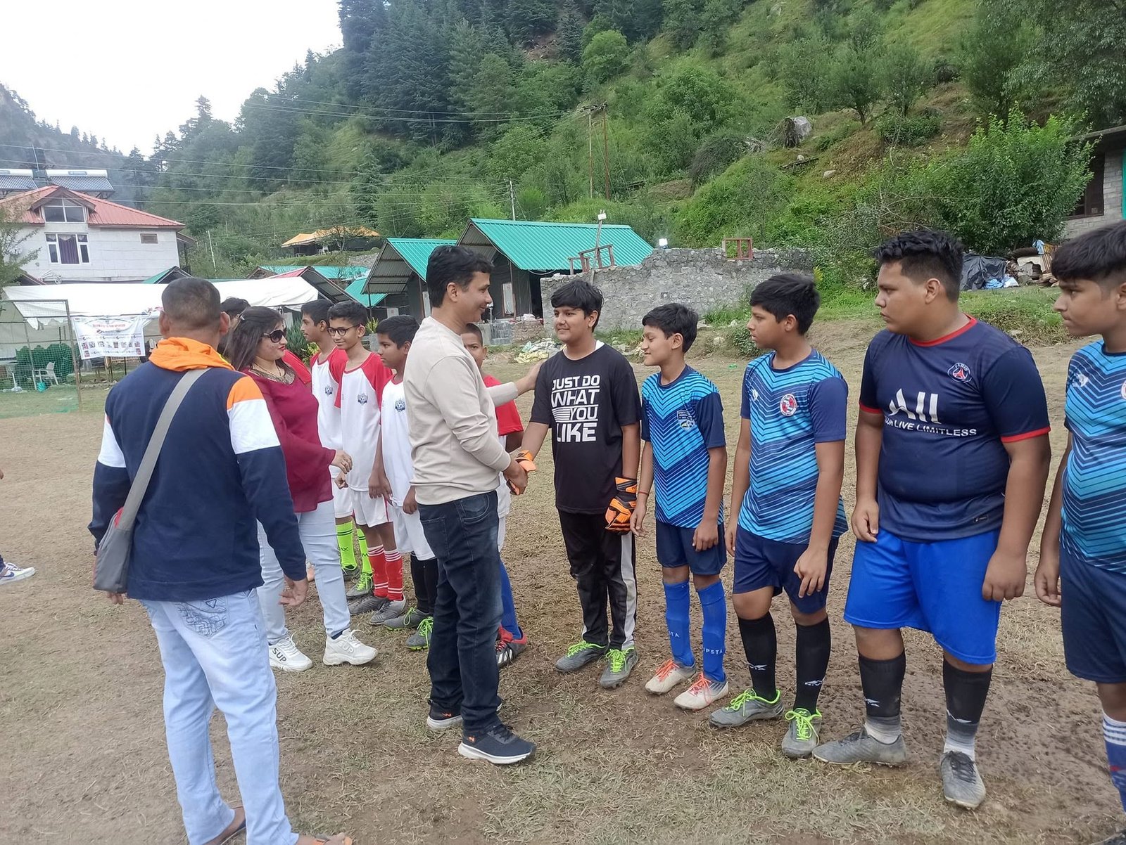 Players and officials line up before kick-off at a hill venue